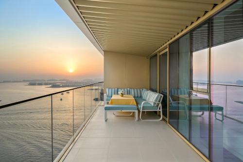 a balcony with a table and chairs and the ocean at Beachfront 2BR Grand Bleu Luxe Near Dubai Palm & Marina Hotspots in Dubai