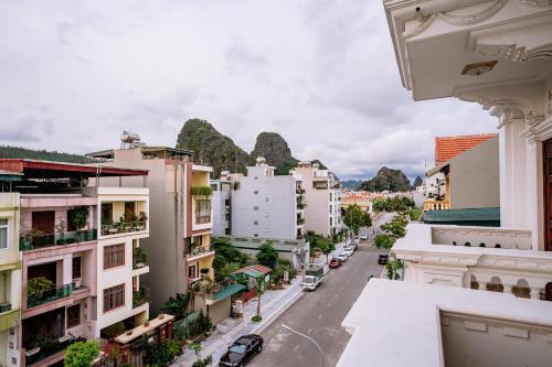 a city street with buildings and mountains in the background at Pearl Hotel Ha Long in Ha Long