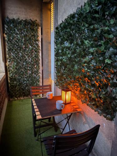 une table avec une lampe et deux chaises devant un mur dans l'établissement Appartement F4 centre Moulins, à Moulins