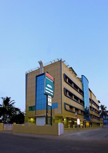 a large building with a sign in front of it at Hotel Indraprastha Kayamkulam in Pattiyūrgrāmam