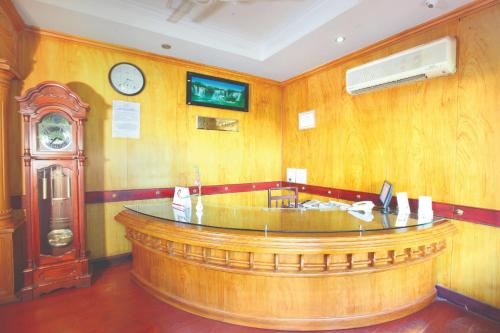a bar in a room with a clock on the wall at Hotel Indraprastha Kayamkulam in Pattiyūrgrāmam
