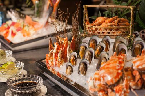 a buffet of food with lobster and other foods at Cheery Dragon Canal Hotel Hangzhou - Intangible Cultural Heritage Hotel in Hangzhou