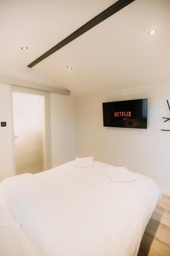 a bedroom with a bed and a tv on the wall at Szépasszony Guest House in Vlăhiţa