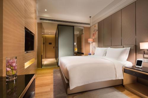 a bedroom with a large white bed in a room at Cheery Dragon Canal Hotel Hangzhou - Intangible Cultural Heritage Hotel in Hangzhou