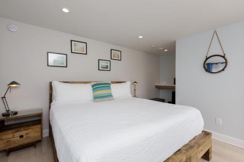 a bedroom with a large white bed and a table at Aqualina Inn Montauk in Montauk