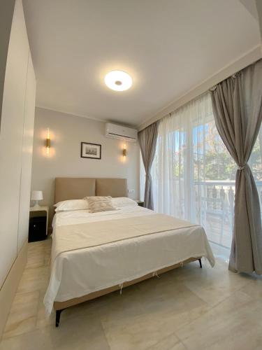 a bedroom with a bed and a large window at Versailles One Garden Villa Full Floor Suite in Koropi