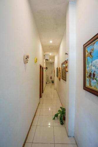 a hallway with white walls and a painting on the wall at Cabin Hotel Ringroad Utara in Seturan