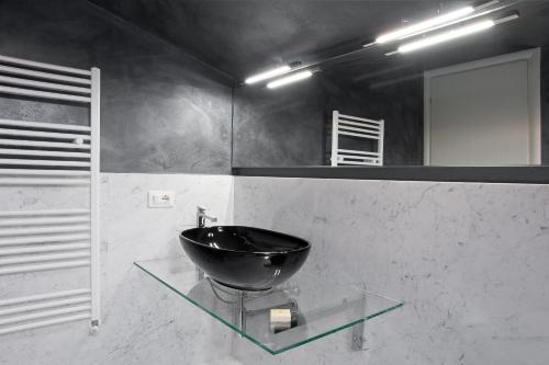 a bathroom with a black sink on a glass table at Hotel Stella Della Versilia in Marina di Massa
