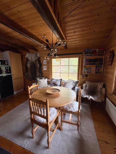 a dining room with a wooden table and chairs at Villa Aiku in Leppäjärvi