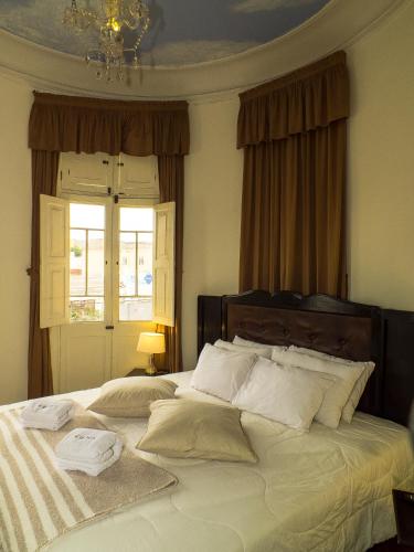 a bedroom with a bed with white pillows and a window at Casa Falleri Boutique Hotel in Lima