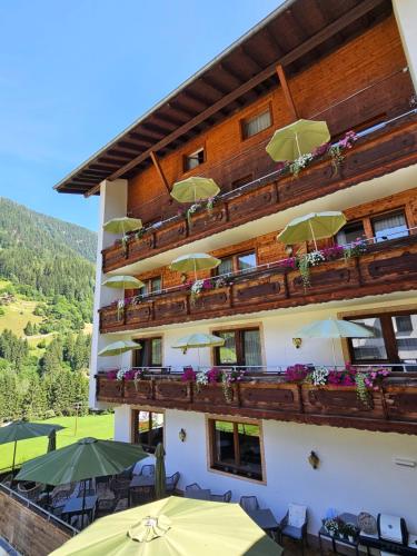 a building with tables and umbrellas on the balcony at Hotel Buckelhof - See - only 20 min from Ischgl in See