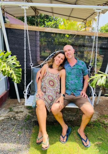 a man and a woman sitting on a swing at Ravana Guest House in Nilaveli