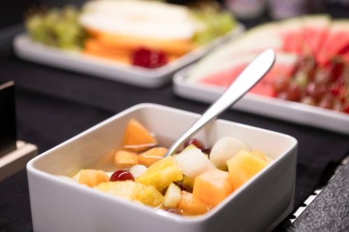 a white bowl of fruit with a spoon in it at Neueröffnung ELVA PREMIUM APARTMENT HOTEL inklusive Sommerpass STUBAI SUPER CARD in Neustift im Stubaital