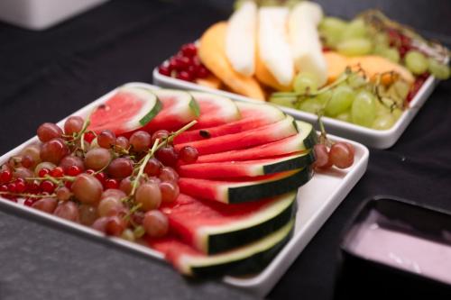 two plates of fruit and vegetables on a table at Neueröffnung ELVA PREMIUM APARTMENT HOTEL inklusive Sommerpass STUBAI SUPER CARD in Neustift im Stubaital