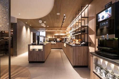 a kitchen with wooden cabinets and a tv on the wall at Neueröffnung ELVA PREMIUM APARTMENT HOTEL inklusive Sommerpass STUBAI SUPER CARD in Neustift im Stubaital