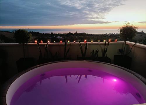 a purple hot tub on a balcony with a sunset at Comfort &Relax B&B&Spa in Villa Rosa