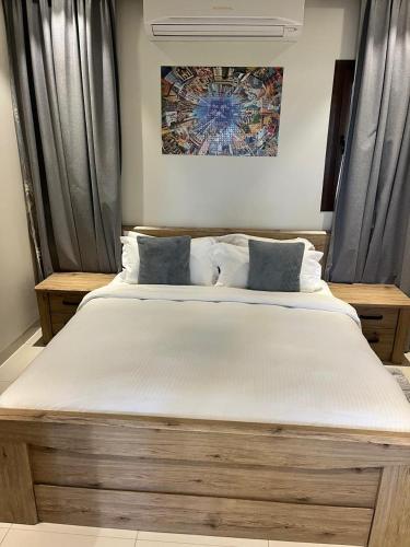 a bedroom with a large white bed with two pillows at Hawana salalah Forest island L3-G01 in Salalah
