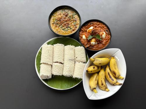 a table with a plate of food and a plate of bananas at Hotel Laals Inn Grand By Jesway Hotels and Resorts in Cochin