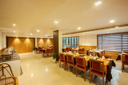 a restaurant with tables and chairs in a room at Hotel Laals Inn Grand By Jesway Hotels and Resorts in Cochin