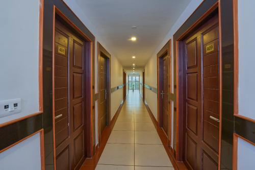 a corridor with wooden doors at Hotel Laals Inn Grand By Jesway Hotels and Resorts in Cochin