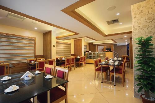 a dining room with tables and chairs in a restaurant at Hotel Laals Inn Grand By Jesway Hotels and Resorts in Cochin