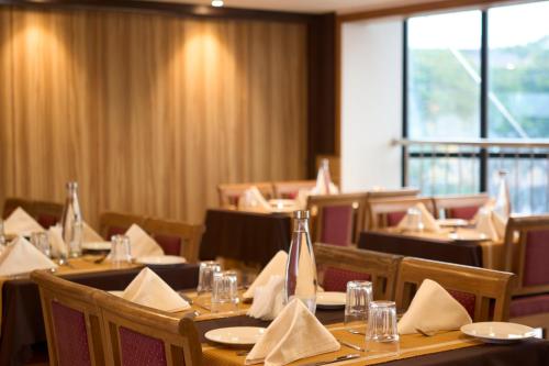 a dining room with tables and chairs with napkins at Hotel Laals Inn Grand By Jesway Hotels and Resorts in Cochin
