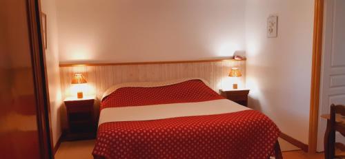 ein Schlafzimmer mit einem roten und weißen Bett mit zwei Lampen in der Unterkunft Gîte Garouille in Saint-Porchaire