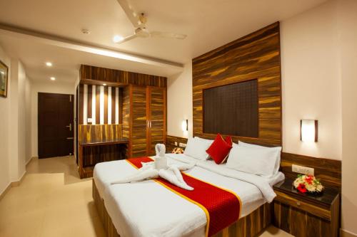 a bedroom with a bed with a teddy bear on it at Hotel Laals Inn Grand By Jesway Hotels and Resorts in Cochin