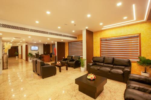 a lobby with leather couches and a waiting room at Hotel Laals Inn Grand By Jesway Hotels and Resorts in Cochin