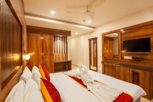 a bedroom with a large white bed with red pillows at Hotel Laals Inn Grand By Jesway Hotels and Resorts in Cochin