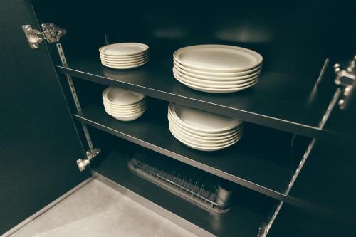 a stack of plates on shelves in a kitchen at illi Lay Shibuya-Ebisu in Tokyo