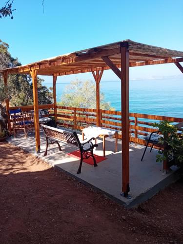 a pavilion with a bench and a table and the ocean at Aegean Heaven in Samos