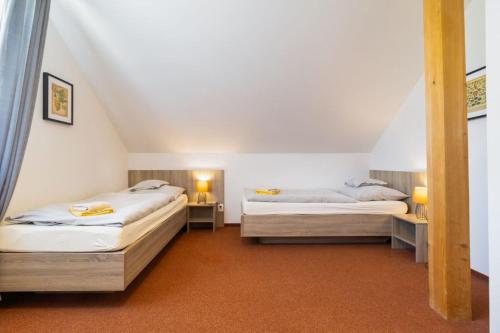 a bedroom with two beds in a attic at Farma Moulisových in Nezvěstice
