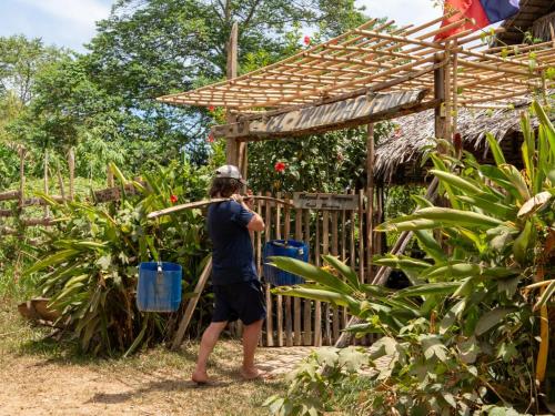 a person standing in front of a wooden fence at El Trinidad Organic Farm in El Nido