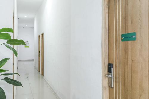 a hallway with a door with a sign on it at RedDoorz near Universitas Hasanuddin Makassar in Makassar
