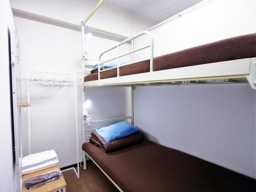 a small room with two bunk beds in it at Omotenashi Hostel Miyajima in Hatsukaichi