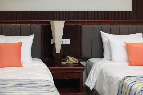 Ένα ή περισσότερα κρεβάτια σε δωμάτιο στο Royal Suites Hotel-Kampala