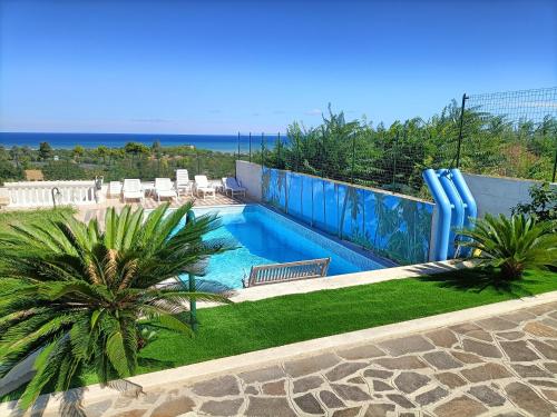 a swimming pool in a yard with palm trees at Comfort &Relax B&B&Spa in Villa Rosa