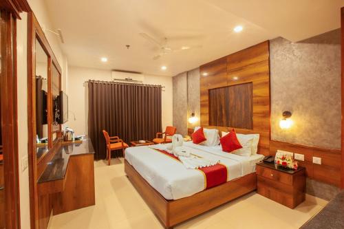 a hotel room with a large bed and a desk at Hotel Laals Inn Grand By Jesway Hotels and Resorts in Cochin