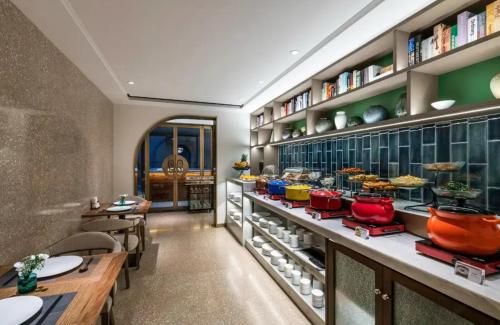 a restaurant with tables and shelves of food at Manxin Hotel - Beijing Zhongguancun University of Technology in Beijing