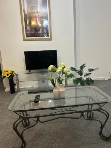 a living room with a glass table with flowers on it at Family Contractor Modern Home Sleeps 7 Free parking in Grimsby