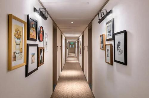 a hallway with many pictures on the walls at Manxin Hotel - Beijing Zhongguancun University of Technology in Beijing