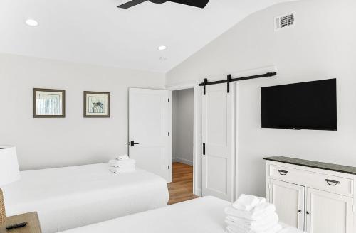 a bedroom with two beds and a flat screen tv at 718 Swordfish Road in Fripp Island