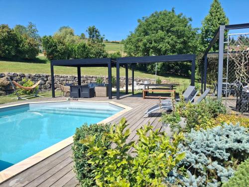 un patio avec une piscine et une table de pique-nique et un pavillon dans l'établissement LA GRANGE BONAL, à Villette