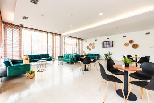 a lobby with green furniture and tables and chairs at Spirit Hotel Fonte Real - Antigo Hotel Flora in Monte Real