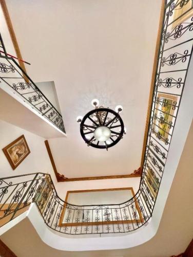 a spiral staircase with a chandelier in a house at Vila Dy Bukurite in Draçi