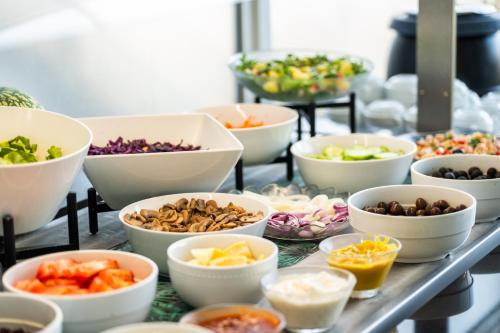 a buffet with bowls of different types of vegetables at Spirit Hotel Fonte Real - Antigo Hotel Flora in Monte Real