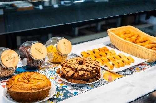 a table with different types of cakes and pastries at Spirit Hotel Fonte Real - Antigo Hotel Flora in Monte Real