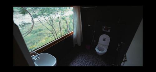 a bathroom with a toilet and a large window at Sopo Resort in Duimukh
