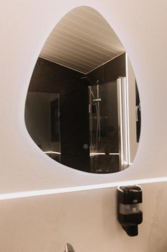 a bathroom with a round mirror on a sink at Szépasszony Guest House in Vlăhiţa